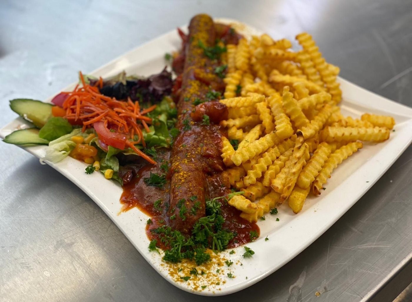 Currywurst mit Pommes und Salat aus der Küche des Künstlerhauses