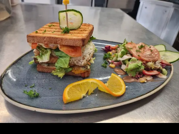 Clubsandwich mit Putenbrust, Spiegelei und Salatbouquet