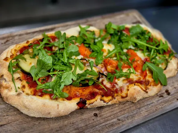 Pinsa Romana mit Tomatensauce, Mozzarella, gegrilltem Gemüse und Rucola